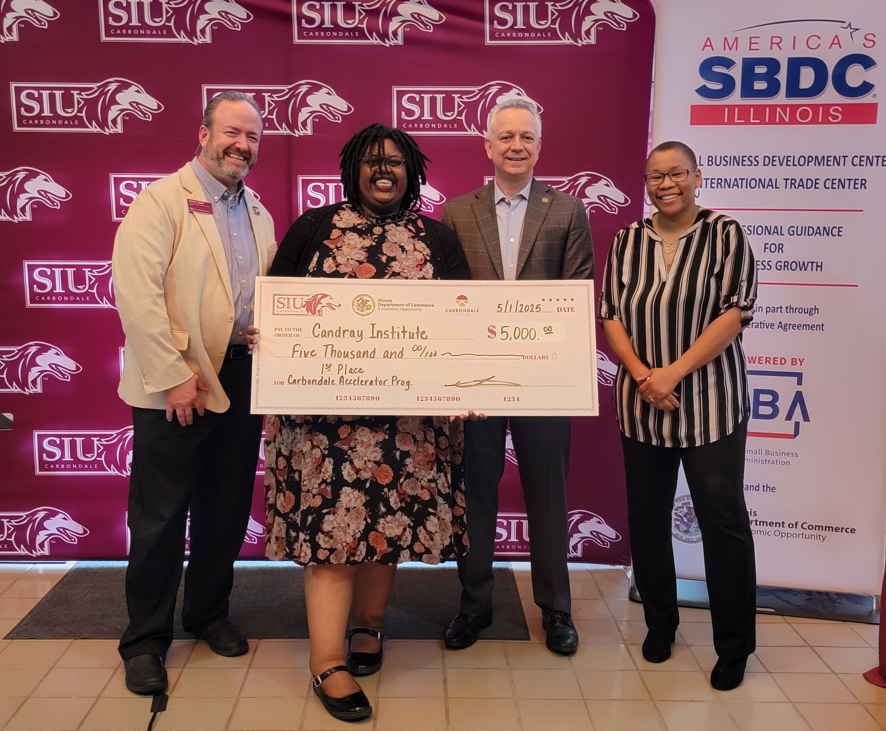 Business Owner AlessandRa Nicholson stands with SBDC and City of Carbondale staff holding a ceremonial check for $5000. 