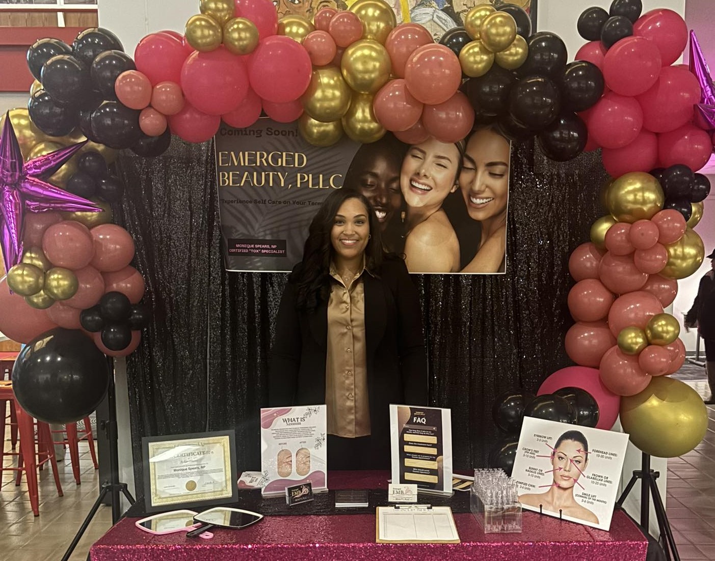 Monique Spears stands behind her display table at a vendor event. 